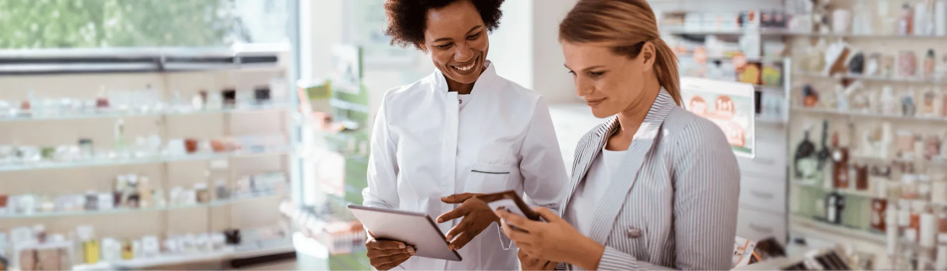 IA no varejo: como está transformando o atendimento e a experiência do cliente Funcionária de farmácia atendendo cliente enquanto segura tablet.